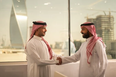 اجتماع عمل وانجاز المشاريع, شرح واعطاء الخبرات بين الزملاء، التركيز والعمل المتقن, الحوارات والنقاشات ضمن الفريق,تطوير الاعمال والشركات, مناقشة الخطط وشرح مهام الاعمال, زملاء عمل عرب سعوديين خليجيين يرتدون الزى التقليدي والشماغ يتبادلان الحديث