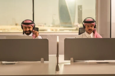 الحوارات والنقاشات ضمن الفريق, أماكن مخصصة لكل موظف في الشركة، التركيز والعمل المتقن,تطوير الاعمال والشركات, اجتماع عمل وانجاز المشاريع, مناقشة الخطط وشرح مهام الاعمال, زملاء عمل عرب سعوديين خليجيين يرتدون الزى التقليدي والشماغ  وسماعات الرأس يستخدمون الحاسوب المحمول