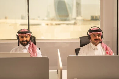 التركيز والعمل المتقن, أماكن مخصصة لكل موظف في الشركة، الحوارات والنقاشات ضمن الفريق,تطوير الاعمال والشركات, اجتماع عمل وانجاز المشاريع, مناقشة الخطط وشرح مهام الاعمال, زملاء عمل عرب سعوديين خليجيين يرتدون الزى التقليدي والشماغ  وسماعات الرأس يستخدمون الحاسوب المحمول