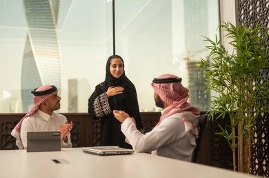 Team discussions and dialogues, business and company development, work meetings and project completion, focus and meticulous work, discussing plans and explaining work tasks, Arab Saudi Gulf colleagues in a meeting, Saudi employees using laptops and tablets.