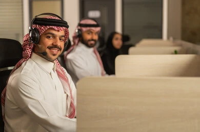 أماكن مخصصة لكل موظف في الشركة، التركيز والعمل المتقن, الحوارات والنقاشات ضمن الفريق,تطوير الاعمال والشركات, اجتماع عمل وانجاز المشاريع, مناقشة الخطط وشرح مهام الاعمال, زملاء عمل عرب سعوديين خليجيين يرتدون الزى التقليدي والشماغ وسماعات الرأس يستخدمون الحاسوب المحمول