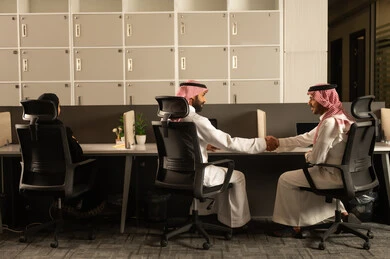 الحوارات والنقاشات ضمن الفريق, أماكن مخصصة لكل موظف في الشركة، التركيز والعمل المتقن, تطوير الاعمال والشركات, اجتماع عمل وانجاز المشاريع, مناقشة الخطط وشرح مهام الاعمال, زملاء عمل عرب سعوديين خليجيين يرتدون الزي التقليدي والشماغ يستخدمون الحاسوب المحمول