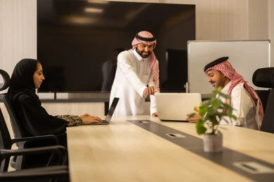 موظفين سعوديين يستخدمون جهاز الحاسوب المحمول ، شرح المهام المطلوبة بسعادة , التعاون والتفاهم بين الفريق, تبادل الخبرات والاتفاقيات الناجحة,تنظيم وادارة اهداف العمل, بيئة العمل المريحة , زملاء عمل عرب سعوديين خليجيين في اجتماع لدراسة المشروع والاهداف بدقة