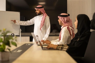 بيئة العمل المريحة , التعاون والتفاهم بين الفريق, تبادل الخبرات والاتفاقيات الناجحة,تنظيم وادارة اهداف العمل, موظفين سعوديين يستخدمون جهاز الحاسوب المحمول ، شرح المهام المطلوبة بسعادة , زملاء عمل عرب سعوديين خليجيين في اجتماع لدراسة المشروع والاهداف بدقة
