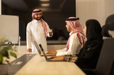 التعاون والتفاهم بين الفريق, تبادل الخبرات والاتفاقيات الناجحة,تنظيم وادارة اهداف العمل, بيئة العمل المريحة , موظفين سعوديين يستخدمون جهاز الحاسوب المحمول ، شرح المهام المطلوبة بسعادة , زملاء عمل عرب سعوديين خليجيين في اجتماع لدراسة المشروع والاهداف بدقة