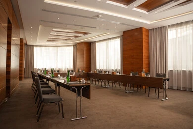 غرفة اجتماعات واسعة مع طاولة محاطة بكراسي، التصميم العصري الحديث للمكاتب في الشركات والمراكز التجارية الاماراتية، النوافذ والواجهات الزجاجية الكبيرة المطلة على الخارج، غرف مكتبية بتصاميم وديكورات داخلية فخمة، قاعة الأعمال وعقد الاتفاقات مع فريق العمل