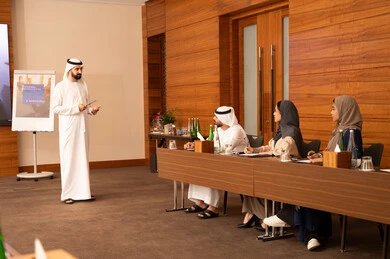 مجموعة من الموظفين العرب الخليجيين الاماراتيين يتعلمون اساليب العمل والتطوير المهني، استخدام الكتابة لضمان حفظ فهم واضح وشامل للاعمال، التعاون والتفاهم بين الزملاء ووضع الخطط الاستراتيجية لتحقيق الأهداف، عقد اجتماع داخل مقر الشركة، العمل الجماعي وروح الفريق