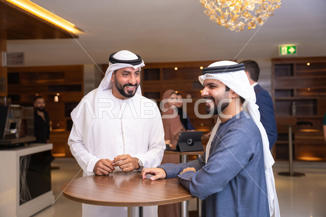 إبرام اتفاقيات وصفقات عمل ناجحة، شركات الإمارات العربية المتحدة، النقاش والتفاهم بين الموظفين، تبادل الخبرات والمعلومات لتحقيق الاهداف، التخطيط الاستراتيجي والتنظيم، رجلين أعمال عربيين خليجيين اماراتيين يناقشون اساليب العمل والتطوير المهني