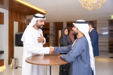 استراتيجيات شركات الإمارات العربية المتحدة، الشراكة والتعاون في إنجاز المهام، النقاش والتفاهم بين الموظفين، تبادل الخبرات والمعلومات لتحقيق الاهداف، التخطيط الاستراتيجي والتنظيم، رجلين أعمال عربيين خليجيين اماراتيين يناقشون اساليب العمل والتطوير المهني