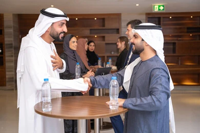 The concept of greeting and peace, companies in the United Arab Emirates, partnership and cooperation in accomplishing tasks, discussion and understanding among employees, exchanging experiences and information to achieve goals, strategic planning and organization, two Arab Gulf businessmen from the UAE discussing work methods and professional development.