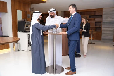 ترحيب وتعارف مع ضيف جديد، النقاش والتفاهم بين الموظفين، تبادل الخبرات والمعلومات لتحقيق الاهداف، التخطيط الاستراتيجي والتنظيم لتحقيق الأهداف، عقد الصفقات الجديدة، مجموعة رجال عربيين خليجيين اماراتيين يناقشون اساليب العمل والتطوير المهني مع سيد اعمال اجنبية