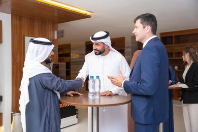 There is love and friendship among the team, discussion and understanding among employees, exchanging experiences and information to achieve goals, strategic planning and organization to achieve objectives, concluding new deals, a group of Arab Gulf Emirati men discussing work methods and professional development with a foreign businessman.