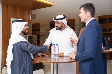 مكاتب وشركات في الامارات العربية المتحدة، النقاش والتفاهم بين الموظفين، تبادل الخبرات والمعلومات لتحقيق الاهداف، التخطيط الاستراتيجي والتنظيم، عقد الصفقات الجديدة، مجموعة رجال عربيين خليجيين اماراتيين يناقشون اساليب العمل والتطوير المهني مع سيد اعمال اجنبية