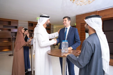 الإتفاق على المشاريع التجارية،  النقاش والتفاهم بين الموظفين، تبادل الخبرات والمعلومات لتحقيق الاهداف، التخطيط الاستراتيجي والتنظيم، عقد الصفقات الجديدة، مجموعة رجال عربيين خليجيين اماراتيين يناقشون اساليب العمل والتطوير المهني مع سيد اعمال اجنبية