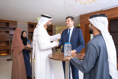 الموافقة على المشاريع التجارية،  النقاش والتفاهم بين الموظفين، تبادل الخبرات والمعلومات لتحقيق الاهداف، التخطيط الاستراتيجي والتنظيم، عقد الصفقات الجديدة، مجموعة رجال عربيين خليجيين اماراتيين يناقشون اساليب العمل والتطوير المهني مع سيد اعمال اجنبية
