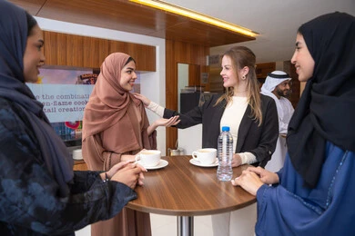 Love and understanding in teamwork, discussion and understanding among employees, exchanging experiences and information to achieve goals, strategic planning and organization to achieve objectives, concluding new deals, a group of Arab Gulf Emirati women discussing work methods and professional development with a foreign businesswoman.