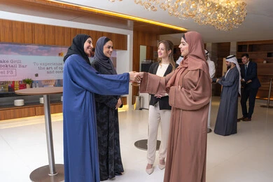 General conversations and work discussions, strategic plans to achieve goals, discussion and understanding among employees, holding a meeting inside the company headquarters, office professions and jobs, attention to elegance and external appearance, a group of Arab Gulf Emirati women discussing work methods and professional development with a foreign businesswoman.