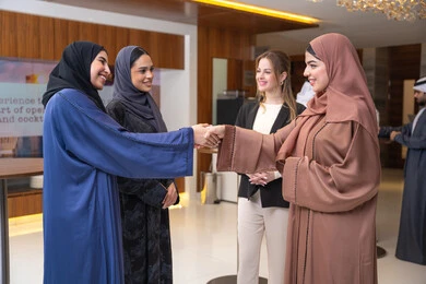 Work discussions and general conversations, strategic plans to achieve goals, discussion and understanding among employees, holding a meeting within the company headquarters, office professions and jobs, attention to elegance and external appearance, a group of Arab Gulf Emirati women discussing work methods and professional development with a foreign businesswoman.