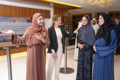 Explanation and definition of the place, strategic plans to achieve goals, discussion and understanding among employees, holding a meeting within the company, office professions and jobs, attention to elegance and external appearance, a group of Arab Gulf Emirati women discussing work methods and professional development with a foreign businesswoman.