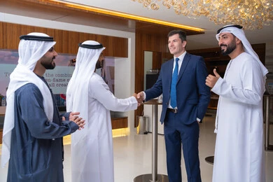 Traditional clothing in a meeting, strategic plans to achieve goals, discussion and understanding among employees, holding a meeting within the company, professions and office jobs, attention to elegance and appearance, a group of Arab Gulf businessmen from the UAE discussing work methods and professional development with a foreign businesswoman.