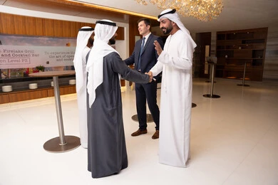 فريق عمل عربي إماراتي، الخطط الاستراتيجية لتحقيق الأهداف، النقاش والتفاهم بين الموظفين، عقد اجتماع داخل الشركة، مهن ووظائف مكتبية، الاهتمم بالاناقة والمظهر الخارجي، مجموعة رجال أعمال عربيين خليجيين اماراتيين يناقشون اساليب العمل والتطوير المهني مع سيد اعمال اجنبية