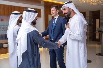 Emirati professions and jobs, strategic plans to achieve goals, discussion and understanding among employees, holding a meeting within the company, office professions and jobs, attention to elegance and external appearance, a group of Arab Gulf Emirati businessmen discussing work methods and professional development with a foreign businesswoman.