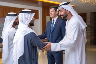 النقاش والتفاهم بين الموظفين، التشارك في إنجاز الاعمال, الخطط الاستراتيجية لتحقيق الأهداف، عقد اجتماع داخل الشركة، مهن ووظائف مكتبية، الاهتمم المظهر الخارجي، مجموعة رجال أعمال عربيين خليجيين اماراتيين يناقشون اساليب العمل والتطوير المهني مع سيد اعمال اجنبية