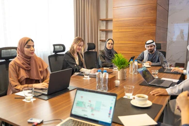176192377 The laptop is used to follow up on work tasks, discussions, and understanding among employees, strategic plans to achieve goals, holding meetings within the company, office professions and jobs, an Arab Gulf Emirati man explaining work methods and professional development to a group of Arab and foreign individuals. 2aggz8ZPpFD