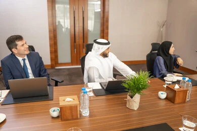 Listening and attentiveness among employees, cooperation between Emirati companies, unity and teamwork, office professions and jobs, using a display screen for clearer explanations, ensuring a clear and comprehensive understanding of business, strategic plans to achieve goals, a group of businessmen discussing work methods and professional development.