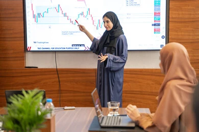 الوحدة والعمل الجماعي، التعاون بين الشركات الاماراتية، مهن ووظائف نسائية، استخدام شاشة العرض لشرح اوضح، ضمان فهم واضح وشامل للاعمال، النقاش والتفاهم بين الموظفين، الخطط الاستراتيجية لتحقيق الأهداف، إمراة عربية خليجية اماراتية تشرح اساليب العمل والتطوير المهني