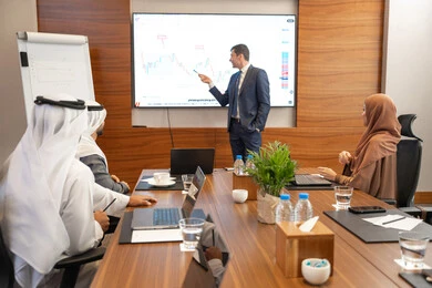 مناقشة اهداف وسياسة الشركة، الحوار والتفاهم بين الموظفين، الوحدة والعمل الجماعي، مهن ووظائف مكتبية، استخدام شاشة العرض لشرح اوضح، ضمان فهم واضح وشامل للاعمال، الخطط الاستراتيجية لتحقيق الأهداف، سيد اعمال اجنبي يناقش اساليب العمل والتطوير المهني داخل شركة امارتية