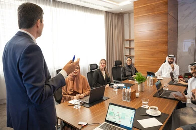 تدريب وتطوير الموظفين، توضيح اهداف وسياسة الشركة، الحوار والتفاهم بين الموظفين، الوحدة والعمل الجماعي، مهن ووظائف مكتبية، استخدام شاشة العرض لشرح اوضح، ضمان فهم واضح وشامل للاعمال، سيد اعمال اجنبي يناقش اساليب العمل والتطوير المهني داخل شركة امارتية