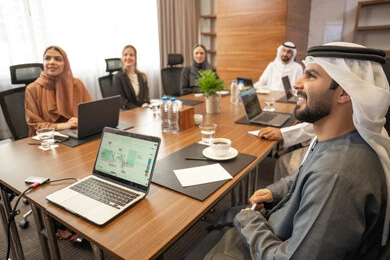 انجاز مهام العمل من خلال الحاسوب المحمول، بيئة عمل إماراتية، دراسة وتحليل المشاريع الجديدة، الحوار والتفاهم بين الموظفين، الوحدة والعمل الجماعي، مهن ووظائف مكتبية، ضمان فهم واضح وشامل للاعمال، سيد اعمال اجنبي في اجتماع عمل داخل شركة اماراتية مع رجل عربي اماراتي