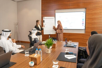 Gestures of self-confidence and seriousness, new partnership deals, an Emirati work environment, dialogue and understanding among employees, unity and teamwork, professions and office jobs, ensuring a clear and comprehensive understanding of business, a foreign businesswoman discussing work methods and professional development with an Emirati woman.