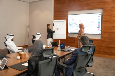 A clear and comprehensive understanding of business, new partnership deals, an Emirati work environment, dialogue and understanding among employees, unity and teamwork, professions and office jobs, ensuring a clear and comprehensive understanding of business, a foreign businesswoman discussing work methods and professional development with an Emirati woman.