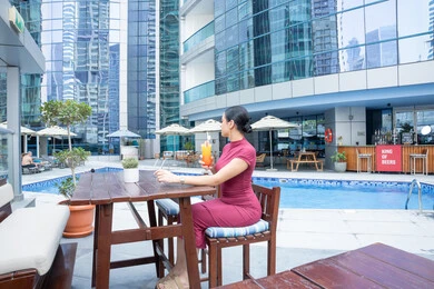 Spending summer vacation at tourist destinations, enjoying refreshing cold drinks, paying attention to style and appearance, the concept of softness and femininity, a young Emirati Gulf Arab woman wearing casual clothes, the joy of spending time with oneself