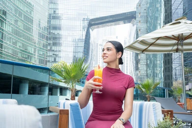 تناول المشروبات المفضلة, الاهتمام بالأناقة والمظهر الخارجي, مفهوم النعومة والأنوثة, الاسترخاء في الهواء الطلق, شابة عربية خليجية اماراتية مبتسمة ترتدي الزي الكاجوال, متعة قضاء الوقت مع الذات