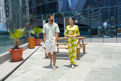 Enjoying and relaxing on vacation, getting ready to swim in the pool, walking along the edge of the water, a happy family atmosphere, enjoying summer trips, a tourist resort, an Emirati Gulf Arab couple wearing casual clothes and taking a stroll