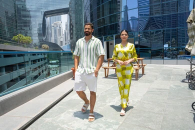 الهروب من ضغوط الحياة، الإستجمام في الهواء الطلق, المشي على حدود البركة المائية, اجواء عائلية سعيدة, الاستمتاع بالرحلات الصيفية, احد المنتجعات السياحية، زوجان عربيان خليجيان اماراتيان يرتديان الزي الكاجوال و يقومان بالتنزه