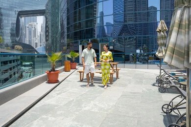 اجواء عائلية سعيدة, انشطة ترفيهية مائية, الاستمتاع بالرحلات الصيفية, اوقات ممتعة في احد المنتجعات السياحية، المشي على حدود بركة السباحة، زوجان عربيان خليجيان اماراتيان يرتديان الزي الكاجوال و يقومان بالتنزه