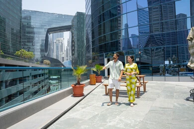 الاستعداد للسباحة في المسبح، اجواء ممتعة والمشي على حدود البركة المائية, اجواء عائلية سعيدة, الاستمتاع بالرحلات الصيفية, احد المنتجعات السياحية، زوجان عربيان خليجيان اماراتيان يرتديان الزي الكاجوال و يقومان بالتنزه