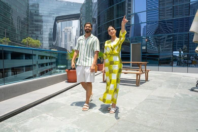 الاستمتاع والتسليه في أوقات الفراغ، الأنشطة الترفيهية والفعاليات المسليه،  المشي على حدود بركة السباحة، زوجان عربيان خليجيان اماراتيان يرتديان الزي الكاجوال و يقومان بالتنزه و تقوم الزوجة بالاشارة باصبع السبابة الى شئ ما