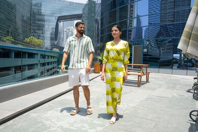 الاستمتاع بالرحلات الصيفية, اوقات ممتعة في احد المنتجعات السياحية، المشي على حدود بركة السباحة، زوجان عربيان خليجيان اماراتيان  يرتديان الزي الكاجوال و يقومان بالتنزه, اجواء عائلية سعيدة, انشطة ترفيهية مائية