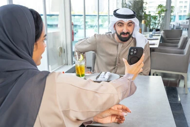 اجتماع عمل في مكان خارج مقر الشركة, دمج التقنيات الحديثة فى الحياة اليومية ،شرب المشروبات المنعشه، قضاء اوقات ممتعة مع الأصدقاء، بناء وتعزيز العلاقات والصداقات،زميلان عمل عربيان خليجيان إماراتيان يجلسان على طاولة في أحد المطاعم الراقية في الإمارات احداهما يعرض شاشة الجوال اجتماع عمل في مكان خارج مقر الشركة, دمج التقنيات الحديثة فى الحياة اليومية ،شرب المشروبات المنعشه، قضاء اوقات ممتعة مع الأصدقاء، بناء وتعزيز العلاقات والصداقات،زميلان عمل عربيان خليجيان إماراتيان يجلسان على طاولة في أحد المطاعم الراقية في الإمارات احداهما يعرض شاشة الجوال