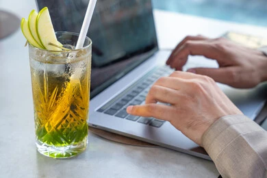 Enjoying refreshing cold drinks, integrating modern technologies into daily life, spending enjoyable times outdoors, building and enhancing relationships and friendships, a business meeting in a place outside the company headquarters, an Emirati Gulf Arab man wearing a kandura and ghutrah sitting at a table in one of the upscale restaurants in the UAE using a laptop. Enjoying refreshing cold drinks, integrating modern technologies into daily life, spending enjoyable times outdoors, building and enhancing relationships and friendships, a business meeting in a place outside the company headquarters, an Emirati Gulf Arab man wearing a kandura and ghutrah sitting at a table in one of the upscale restaurants in the UAE using a laptop.