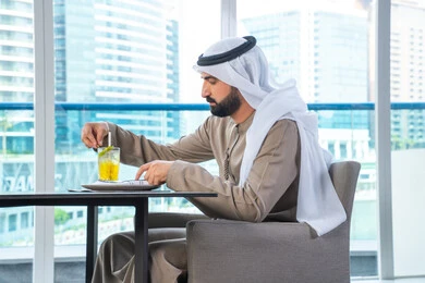قضاء اوقات ممتعة فى الخارج ، مطاعم راقية فى الامارات العربية المتحدة , رجل عربي خليجي اماراتي يرتدي الكندورة والغترة يجلس على طاولة في أحد المطاعم في الإمارات يتناول احدي المشروبات المنعشة قضاء اوقات ممتعة فى الخارج ، مطاعم راقية فى الامارات العربية المتحدة , رجل عربي خليجي اماراتي يرتدي الكندورة والغترة يجلس على طاولة في أحد المطاعم في الإمارات يتناول احدي المشروبات المنعشة