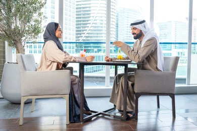 إيماءات السعادة والسرور، قضاء اوقات ممتعة مع الأصدقاء، بناء وتعزيز العلاقات والصداقات، مناقشة الاعمال وتبادل الافكار، اجتماع عمل في مكان خارج مقر الشركة, زميلان عمل عربيان خليجيان إماراتيان يجلسان على طاولة في أحد المطاعم الراقية في الإمارات، يتبادلان الاحاديث والابتسامات إيماءات السعادة والسرور، قضاء اوقات ممتعة مع الأصدقاء، بناء وتعزيز العلاقات والصداقات، مناقشة الاعمال وتبادل الافكار، اجتماع عمل في مكان خارج مقر الشركة, زميلان عمل عربيان خليجيان إماراتيان يجلسان على طاولة في أحد المطاعم الراقية في الإمارات، يتبادلان الاحاديث والابتسامات