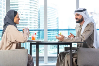 اجتماع عمل في مكان خارج مقر الشركة, إيماءات السعادة والسرور، قضاء اوقات ممتعة مع الأصدقاء، بناء وتعزيز العلاقات والصداقات، مناقشة الاعمال وتبادل الافكار،زميلان عمل عربيان خليجيان إماراتيان يجلسان على طاولة في أحد المطاعم الراقية في الإمارات، يتبادلان الاحاديث والابتسامات اجتماع عمل في مكان خارج مقر الشركة, إيماءات السعادة والسرور، قضاء اوقات ممتعة مع الأصدقاء، بناء وتعزيز العلاقات والصداقات، مناقشة الاعمال وتبادل الافكار،زميلان عمل عربيان خليجيان إماراتيان يجلسان على طاولة في أحد المطاعم الراقية في الإمارات، يتبادلان الاحاديث والابتسامات