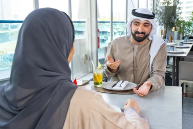 Building and strengthening relationships and friendships, gestures of happiness and joy, spending enjoyable times with friends, discussing business and exchanging ideas, a business meeting in a place outside the company headquarters, two Arab Gulf Emirati colleagues sitting at a table in one of the upscale restaurants in the UAE, exchanging conversations and smiles. Building and strengthening relationships and friendships, gestures of happiness and joy, spending enjoyable times with friends, discussing business and exchanging ideas, a business meeting in a place outside the company headquarters, two Arab Gulf Emirati colleagues sitting at a table in one of the upscale restaurants in the UAE, exchanging conversations and smiles.