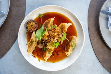 وصفات وأطباق شهية ولذيذة، فنون التقديم في مطابخ الامارات العربية المتحدة، طبق الدجاج المحشو مغمور بصلصة غنية بالنكهات مزين بأوراق الريحان والليمون المشوي وتوابل طازجة، وجبات الطعام الشهية، مطاعم عربية خلجية اماراتية